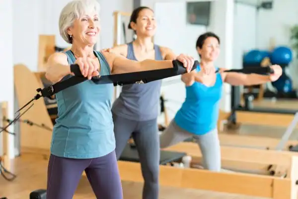 Toning Arms After 60: Empowering Womens Fitness Through Effective Weight Training 2 older woman doing weight training Sunbury and resistance in the gym to tone upper arms