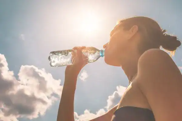 Hydration: The Secret Ingredient for a Toned Stomach and Enhanced Fitness 3 Image of woman drinking water to hydrate Sunbury after run.