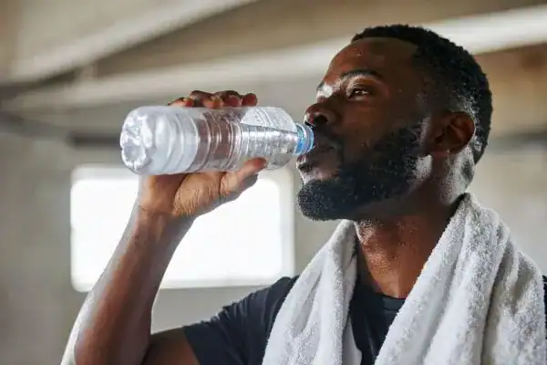 Hydration: The Secret Ingredient for a Toned Stomach and Enhanced Fitness 1 Image of man drinking water to improve hydration Sunbury after work out.